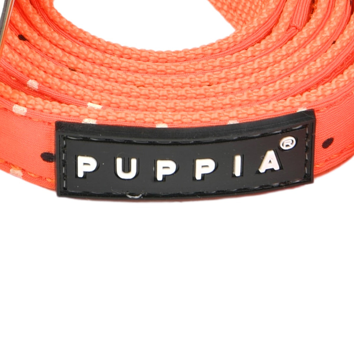 Close-up of a red dog leash with Puppia branding on a white background